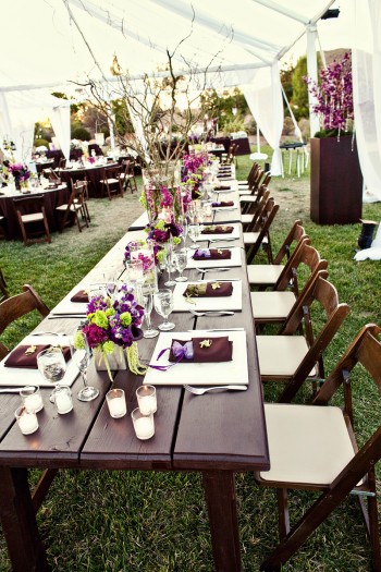 long-brown-wood-estate-tables-purple-green-centerpieces-white-tent