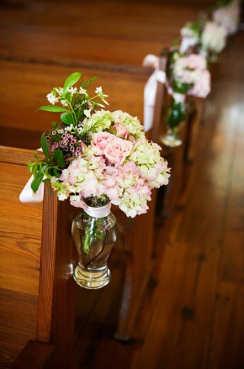 pink-and-green-flowers-in-glass-vase-tied-to-chapel-aisle pink-and-green-flowers-in-glass-vase-tied-to-chapel-aisle