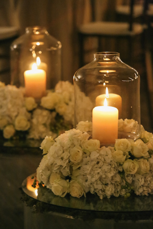 Candles With Hurricanes and White Floral Wreaths