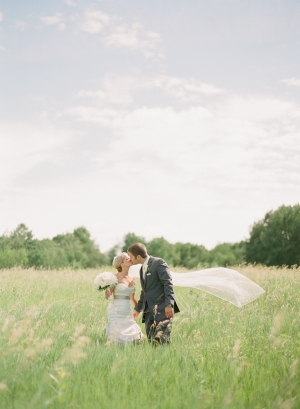 Bride and Groom Kissing in Field